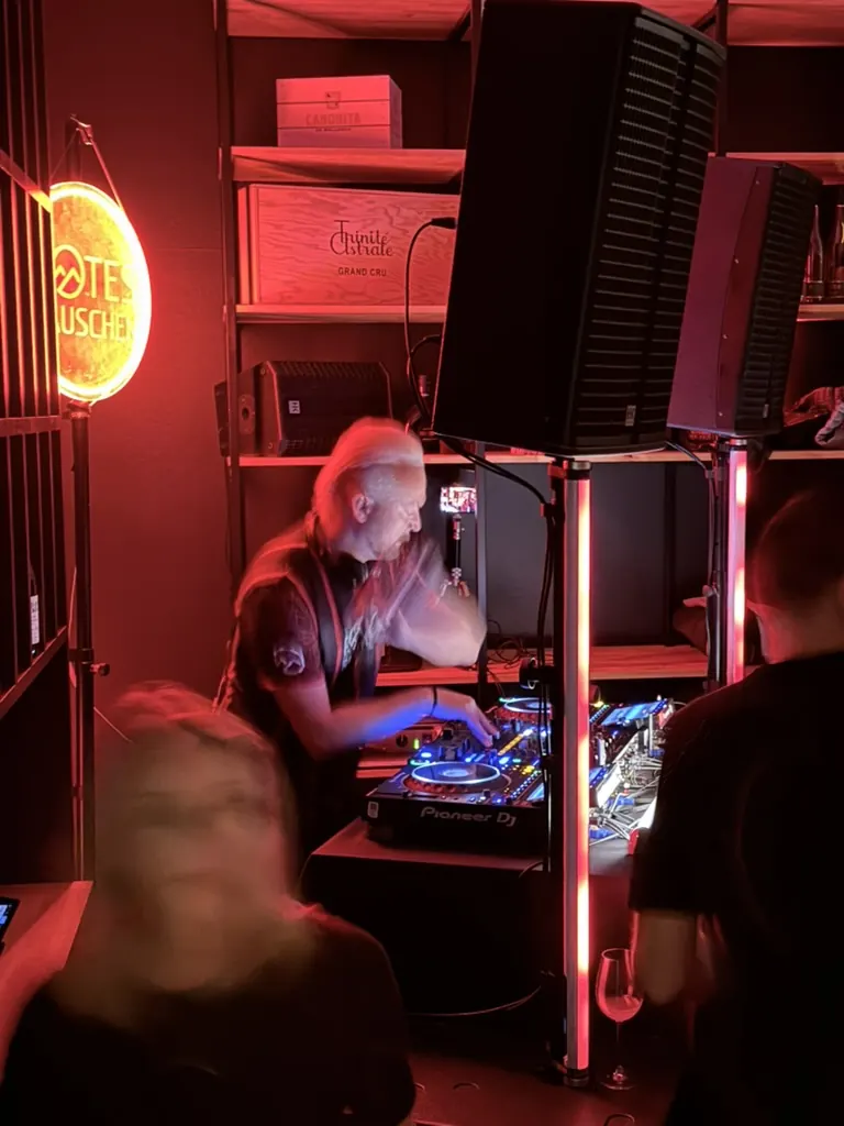 DJ am Mischpult bei roter Beleuchtung in der Weinbar
