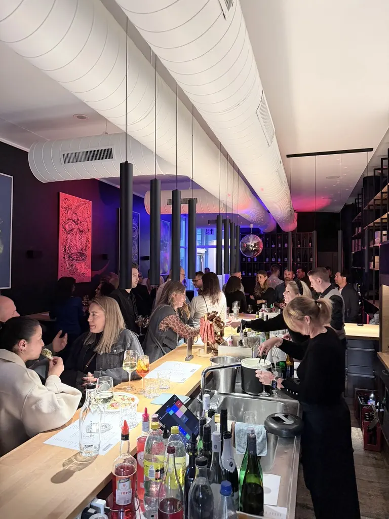 Viele Gäste im Gespräch an der belebten Bar bei DEISTERS