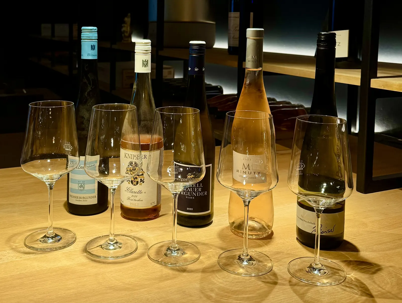 Fünf Weinflaschen und Weingläser für eine Weinprobe bei DEISTERS